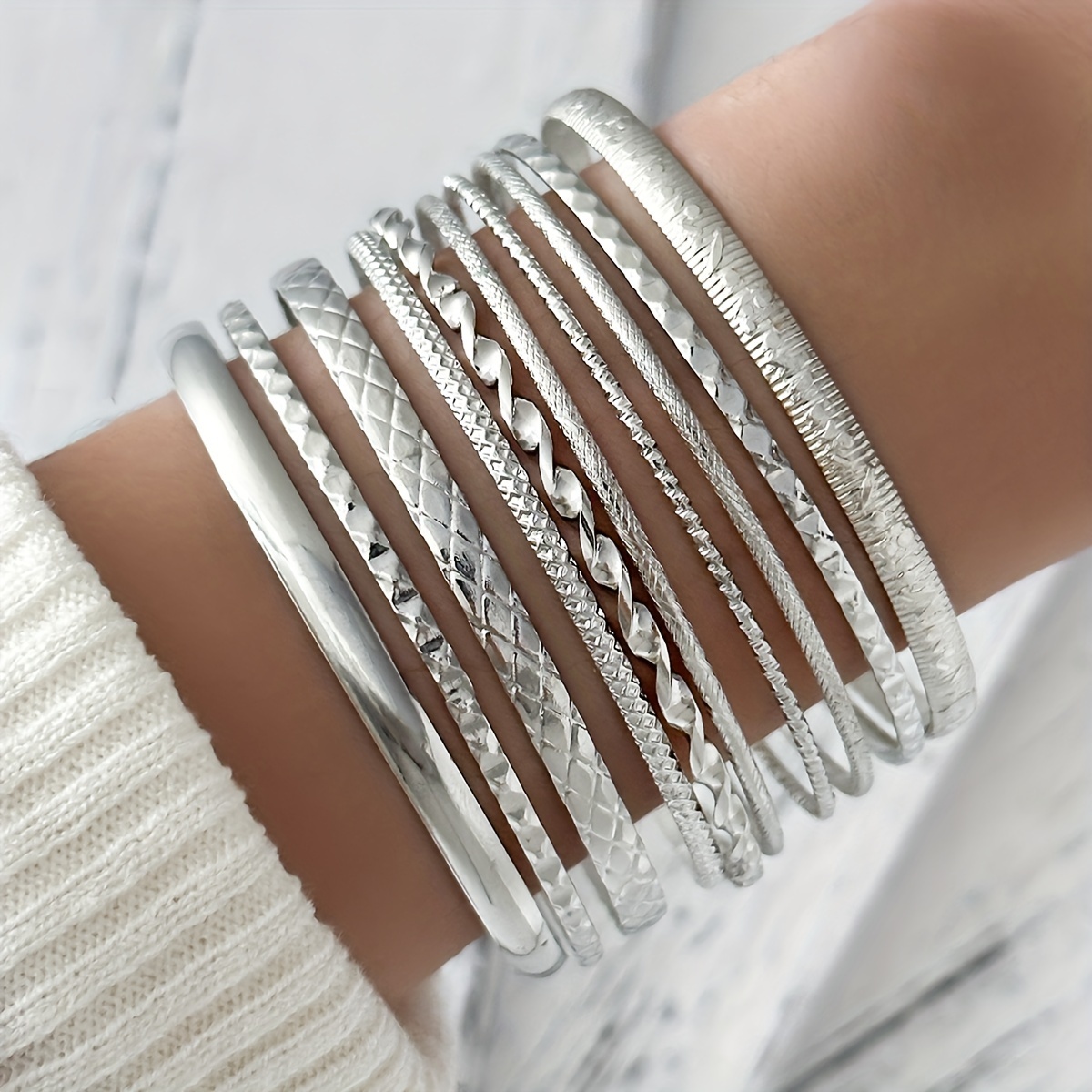 E-shop Ein Set aus 10 minimalistischen, klassischen Basic-Armbändern mit floraler Textur, erhältlich in zwei Farben, zum Stapeln.