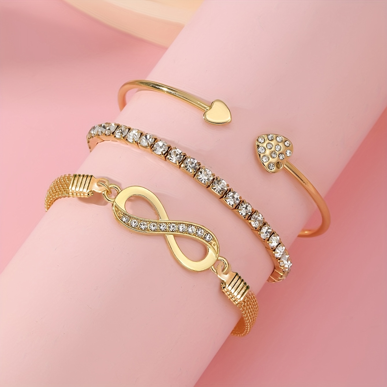 A Set of Three Women'S Bracelets And Bangles Featuring Wireless Symbols And Heart Designs Adorned with Rhinestones.