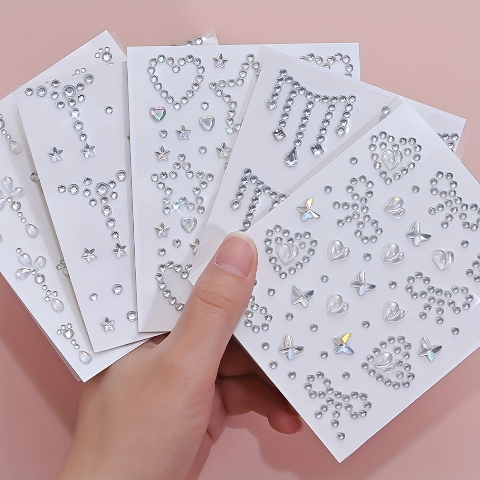 E-shop Fünf Bögen 3D Glitzernde AB Diamant Gesichts-Aufkleber mit Herz- und Schmetterlingsdesigns. Diese selbstklebenden, glitzernden Strass-Aufkleber