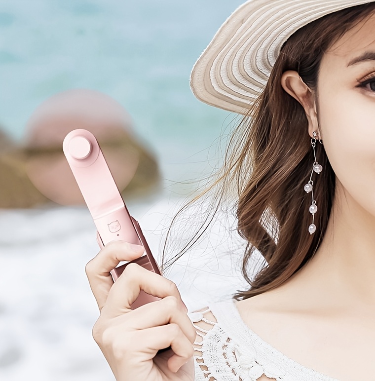 Un ventilateur portable qui double d'une banque d'alimentation, mini et pliable, silencieux pour une utilisation en dortoirs ou bureaux sur un bureau.