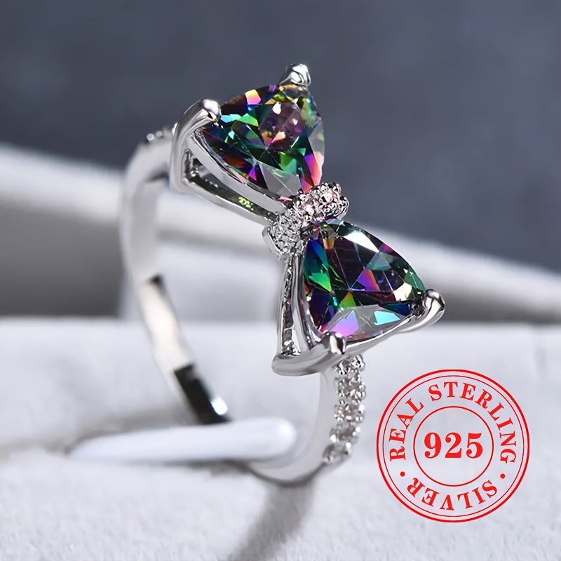 

A Stylish And Unique Ring For Ladies Made Of 2. Of S925 Sterling Silver With Artificial Colored Gemstones In Of A Bow, Suitable For Daily Casual Wear.