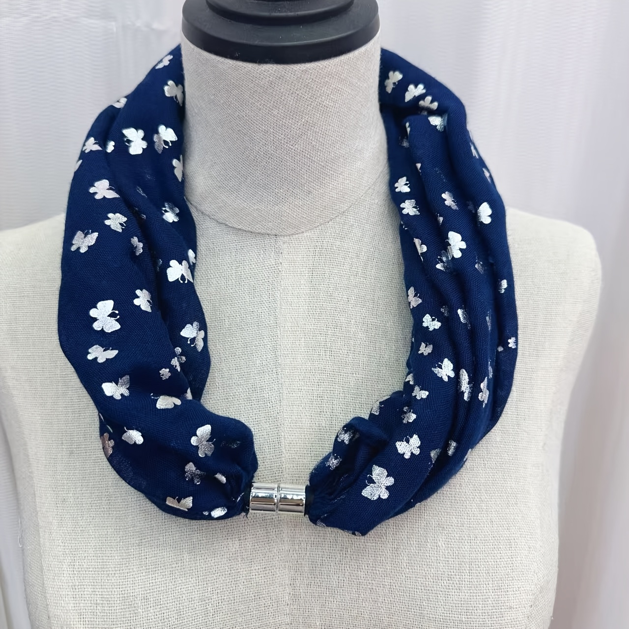 Image of A Silvery-embossed Neck Scarf With A Magnetic Clasp, Made From Soft And Comfortable Fabric. And Stylish, Suitable For Occasions, And Has A Easy Yet Elegant Design