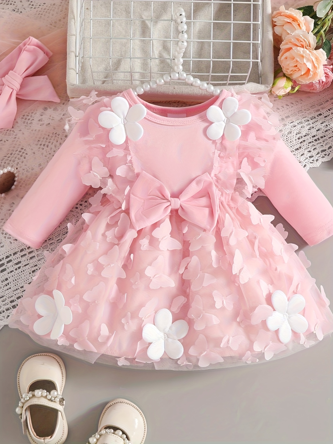 Dit is een witte doopjurk met lange mouwen voor pasgeboren meisjes