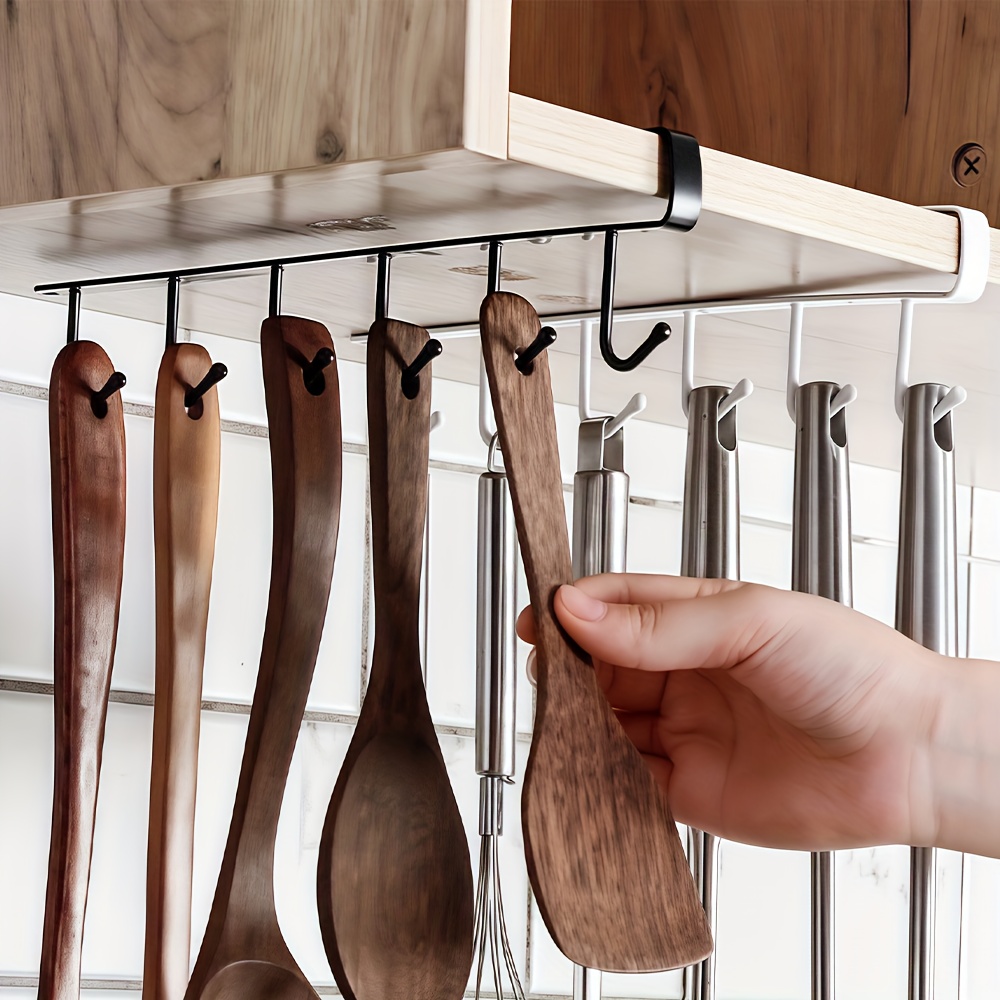a golden metal hook designed for wall mounted cabinet doors featuring a   capacity and a sleek easy design this   non marking clothing hook is perfect for kitchens bathrooms and dorm rooms utility hooks
