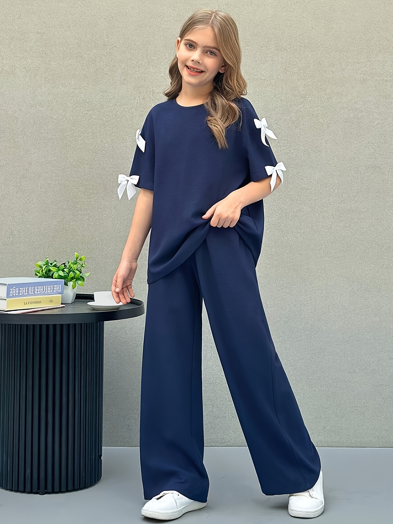 Girls adorable two piece outfit featuring a round neck tee with 3D bow detail and matching straight leg pants perfect for outdoor play
