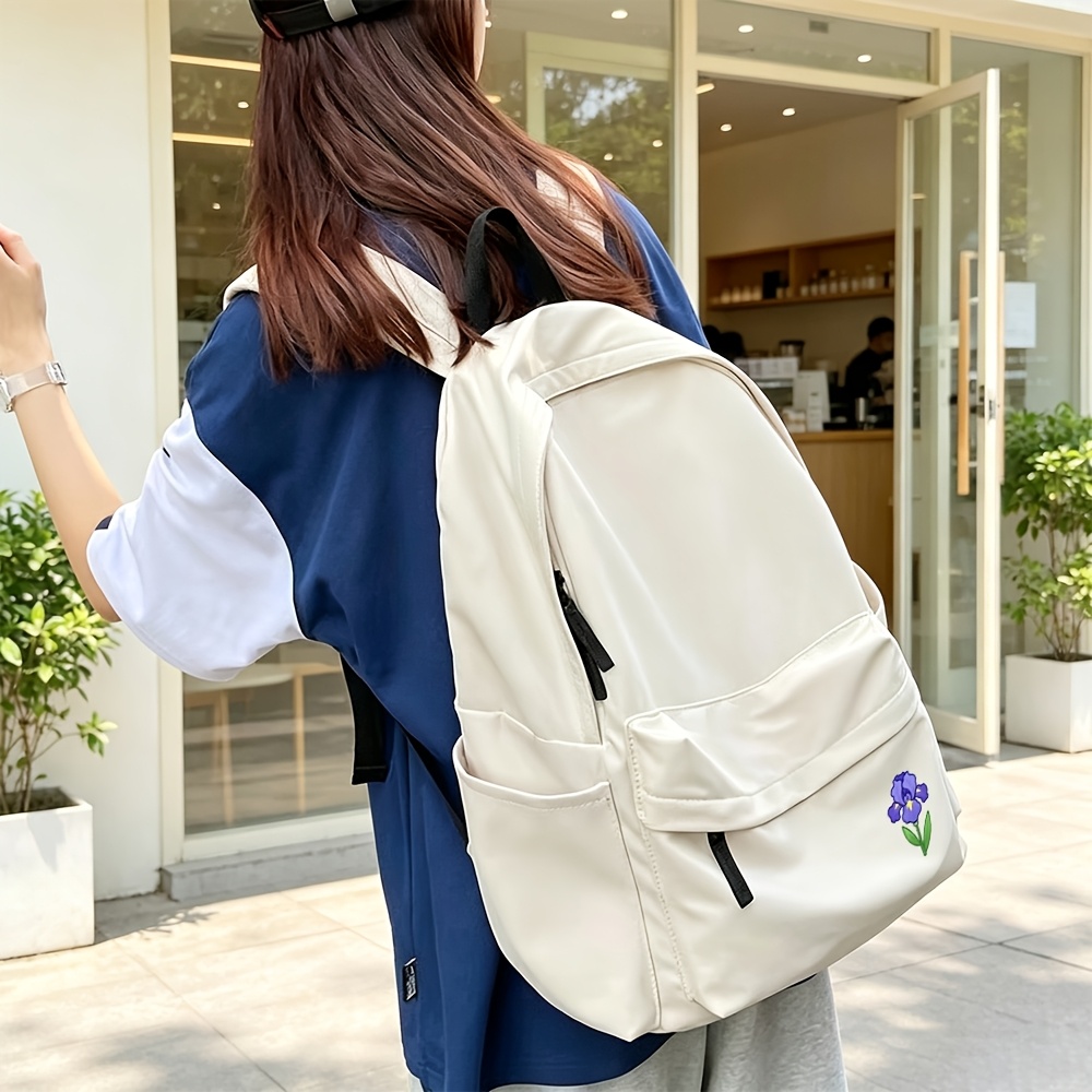backpack   in black and featuring a 2d   flower print made of   resistant fabric with   flap pocket and dual side water bottle holders this large capacity multi purpose backpack is stylish and simple
