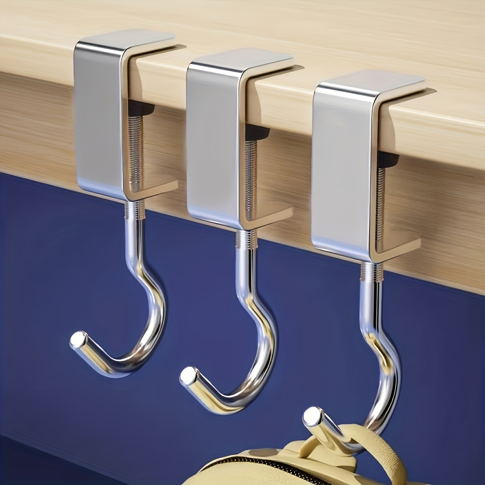 Un gancho plateado ajustable para mochilas, perfecto para muebles y escritorios de dormitorio, diseñado específicamente para colgar bolsos, ganchos utilitarios