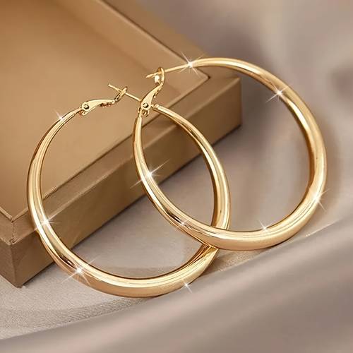 a pair of minimalist yet oversized hoop earrings niche and high end stud earrings womens jewelry suitable for daily commuting