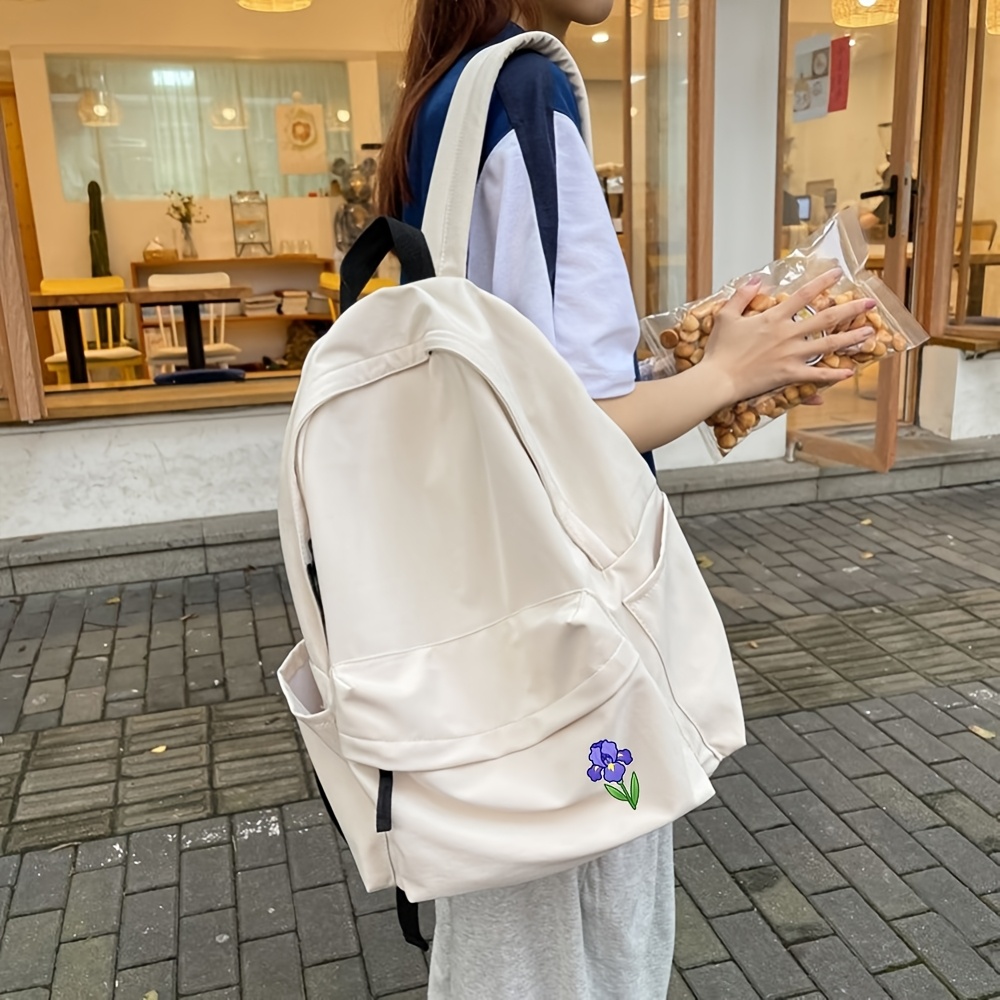 item picture backpack   in black and featuring a 2d   flower print made of   resistant fabric with   flap pocket and dual side water bottle holders this large capacity multi purpose backpack is stylish and simple