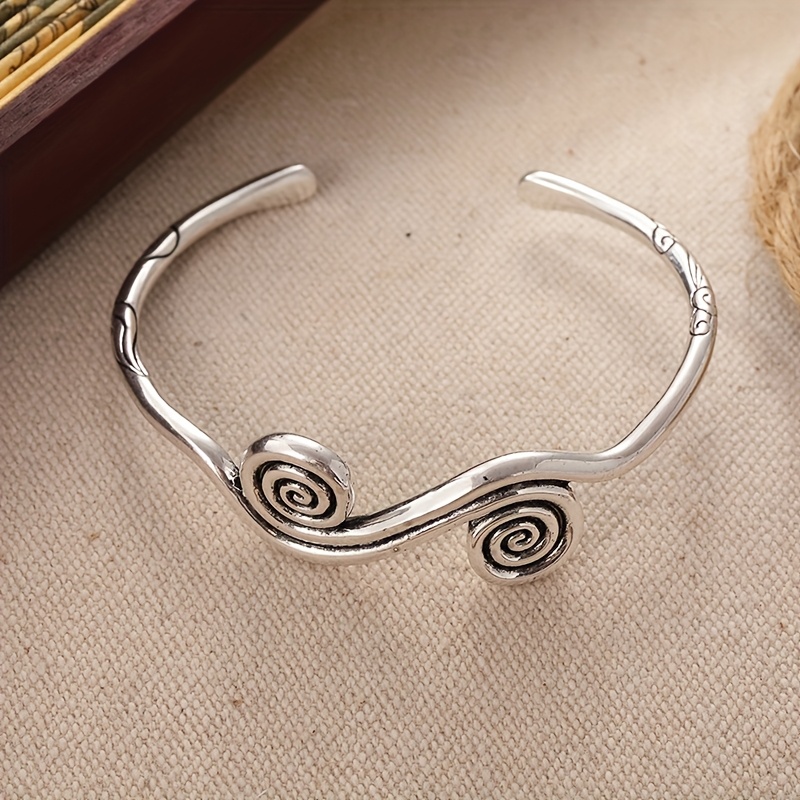 E-shop Dieses Armband strahlt ein zeitloses und geheimnisvolles künstlerisches Flair aus. Sein Spiralmuster ist reich an dynamischem Rhythmus und