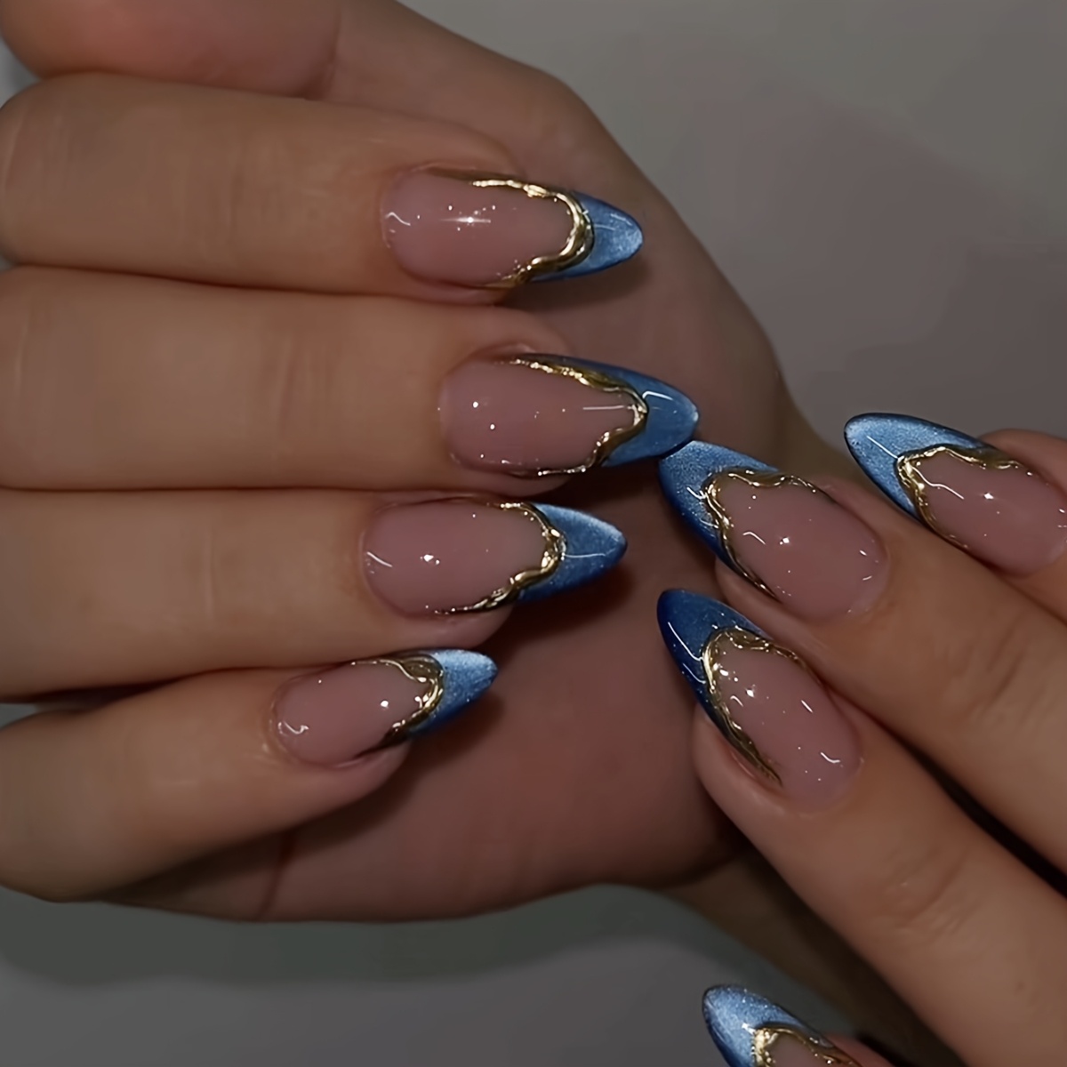 Image of 1 Set Of 24pcs Medium Size Press-on Nails, Featuring Cat-eye Blue French Nail Design With Embossed Golden Lines. Have Shiny And Flexible Gel Tips, With Cute Nude-colored Chrome Nail Stickers