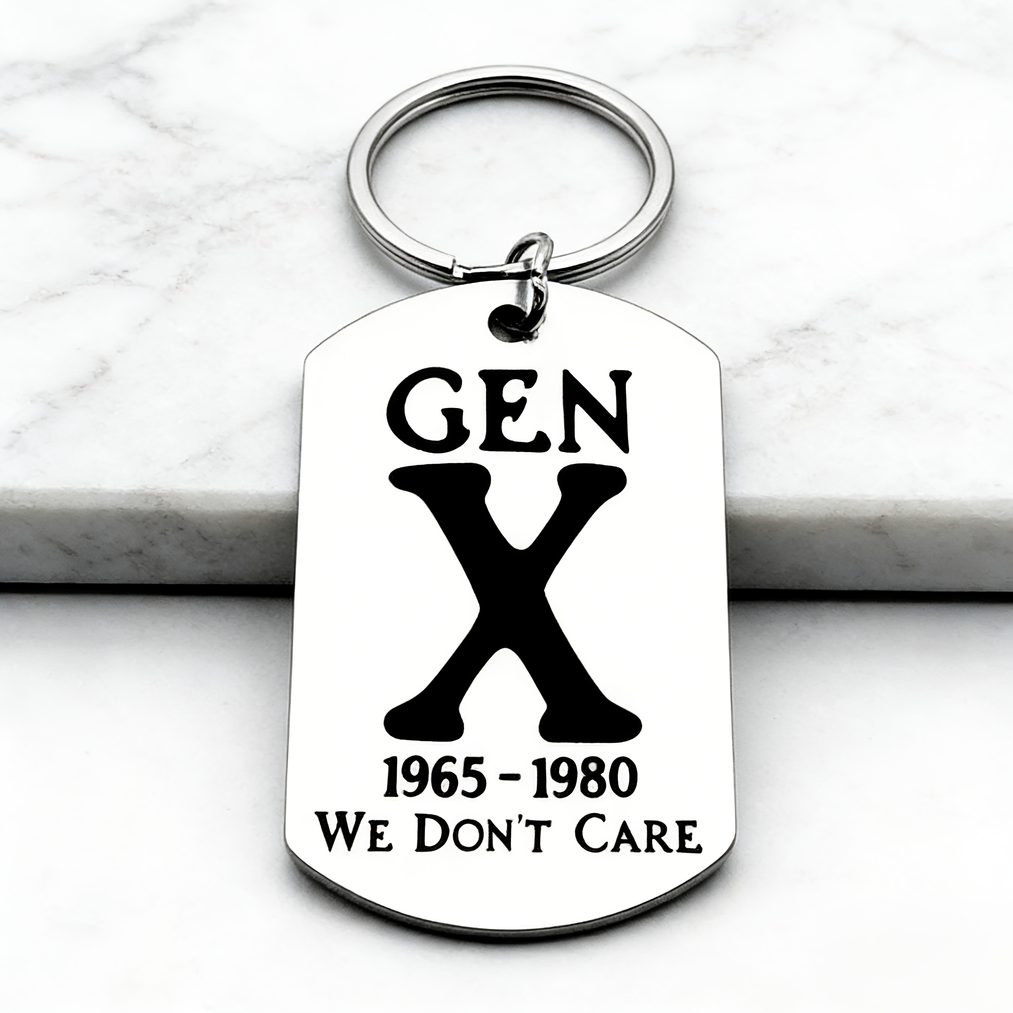 Image of A Stainless Steel Keychain Engraved With " 1965-1980 We Don't Care," A Trendy Attitude Symbol Of The Vintagex Generation . A Unique Accessory, It Makes An Ideal Gift For