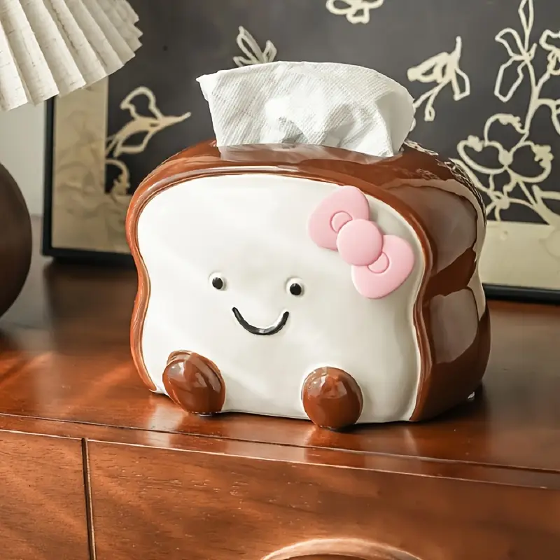 visually appealing toast shaped ceramic tissue box holder smiling bread design with pink flower detail accents living room bedroom or kitchen decor Product details 1