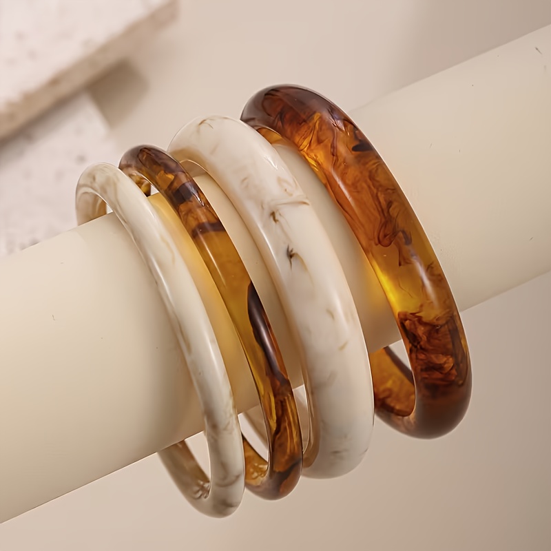 E-shop Ein Set aus 4 stilvollen und minimalistisch gestalteten Damenarmbändern im eleganten Vintage-Stil, geeignet für lässige Alltagsoutfits.