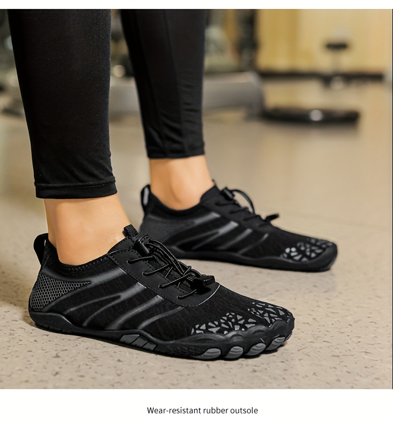 Black deadlift shoes worn with black leggings on a blurred indoor background