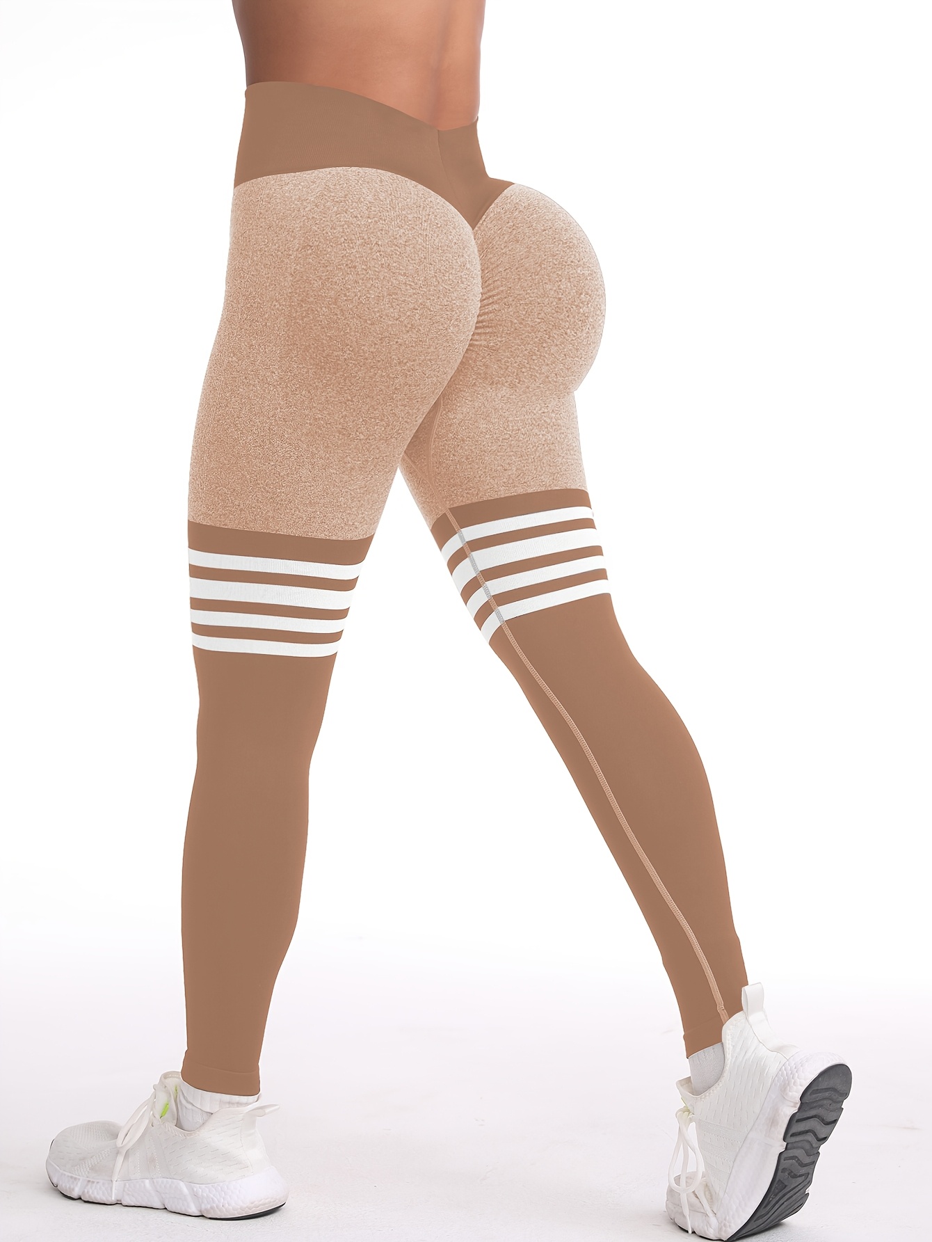A woman wearing a brown yoga leggings sold by 100 Spartans