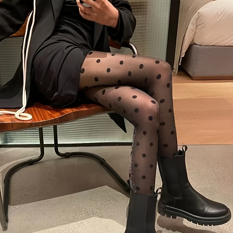 

Une paire de collants noirs avec de grandes taches rondes qui mettent en valeur la des jambes.