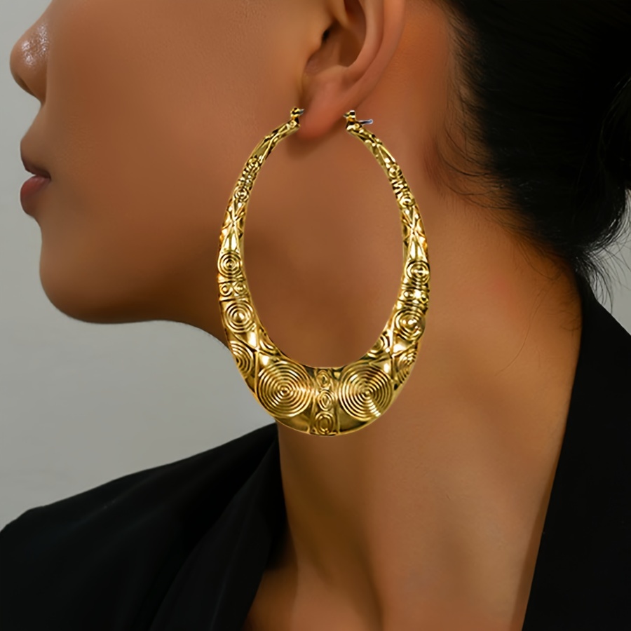 

Une Paire De Boucles D'oreilles Extravagantes En Or Avec Un Motif Géométrique Ovale Creux En Bambou, De Style Rétro Et De Grande Taille.