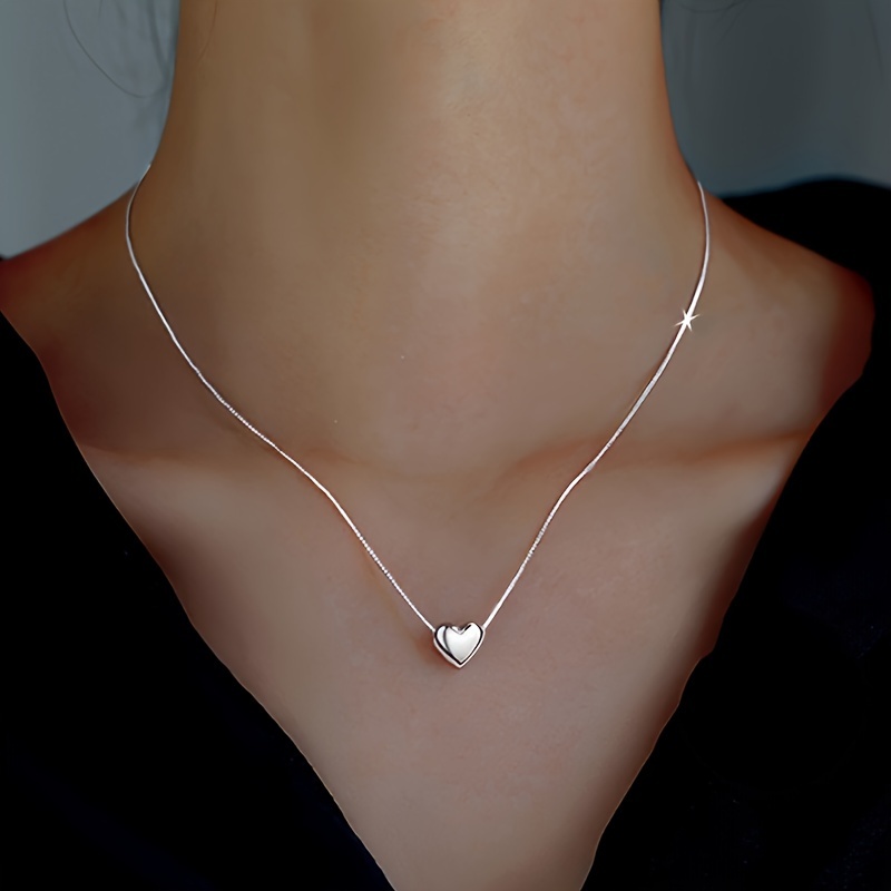 

A Necklace With A Silvery, Heart-shaped Pendant, Pendant Necklace, Jewelry Decoration