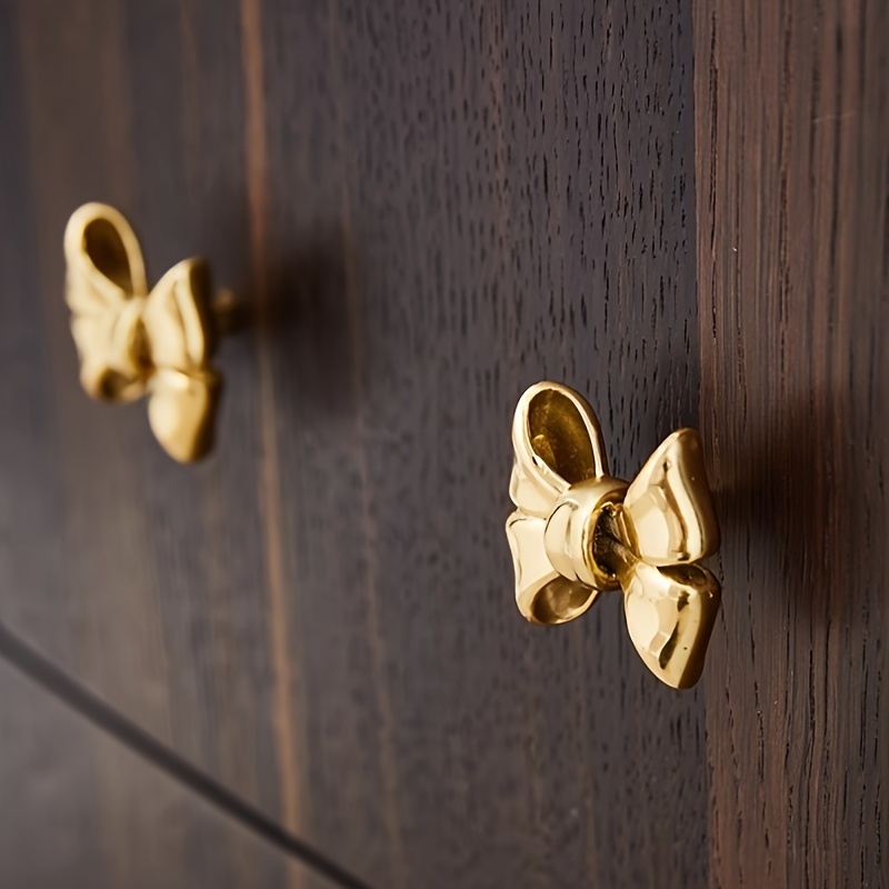 a modern minimalist brass bow shaped drawer handle in golden - Temu Kuwait