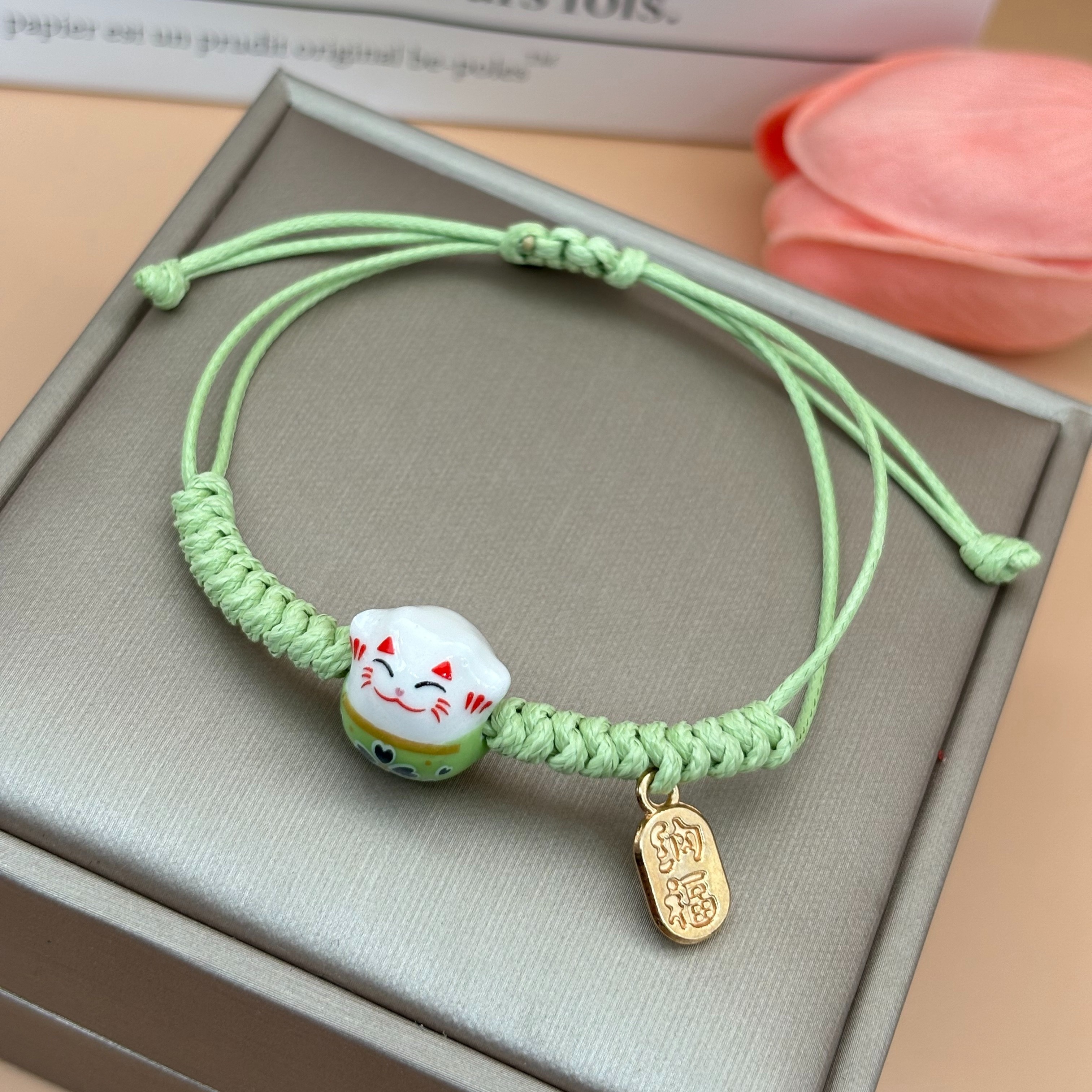 

Bracelet de charme Maneki Neko en céramique festive - Cordon tressé bleu fait main - Convient pour 15 ans et plus - Pas de gravures - Charme en céramique - Pas de placage électrolytique