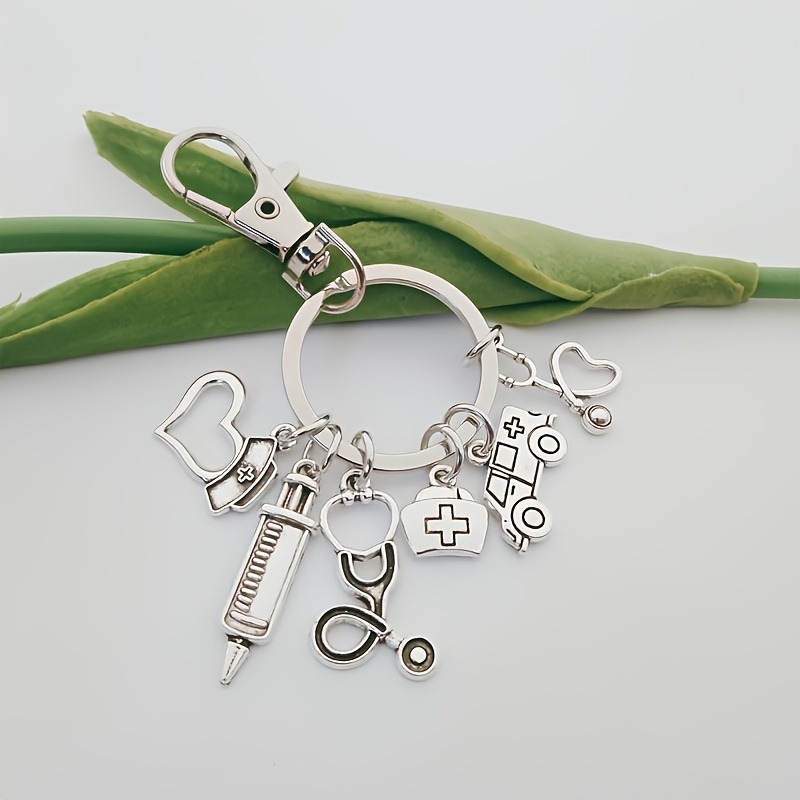A Medical-themed Keychain Made Of Silvery-gray Alloy Featuring A, Ambulance, Cap, And Stethoscope, Designed As A Casual Accessory And A Metal Gift For Healthcare Professionals