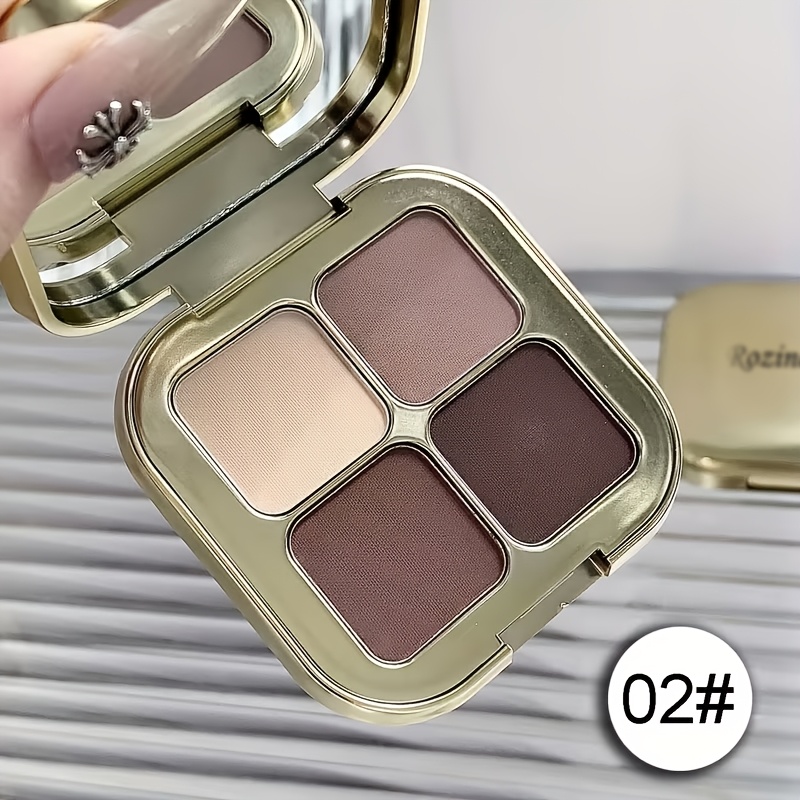 Image of Four-color Eyeshadow Palette With A Golden Texture And A Shiny , Featuring Matte And Shades In Light Beige, Earthy Tones, Purple, And Pink. It Includes A Mirror For Easy Touch-ups, Long-