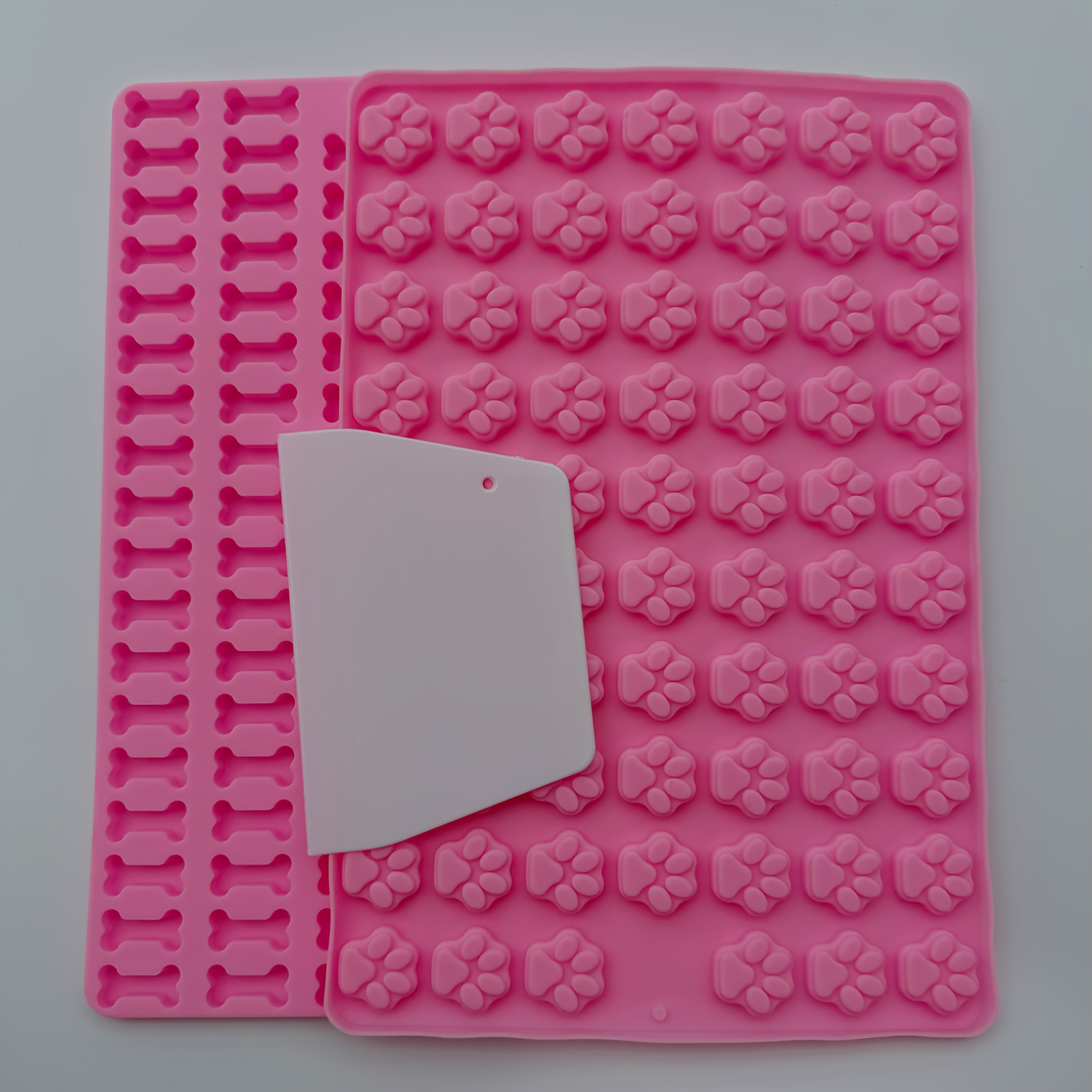 Image of Small Silicone Mold For Dog Treats, Featuring Designs Of A Dog Bone And Paw Print, Includes 2 Food-safe Chocolate Molds And 1 Scraper For Baking And Candies