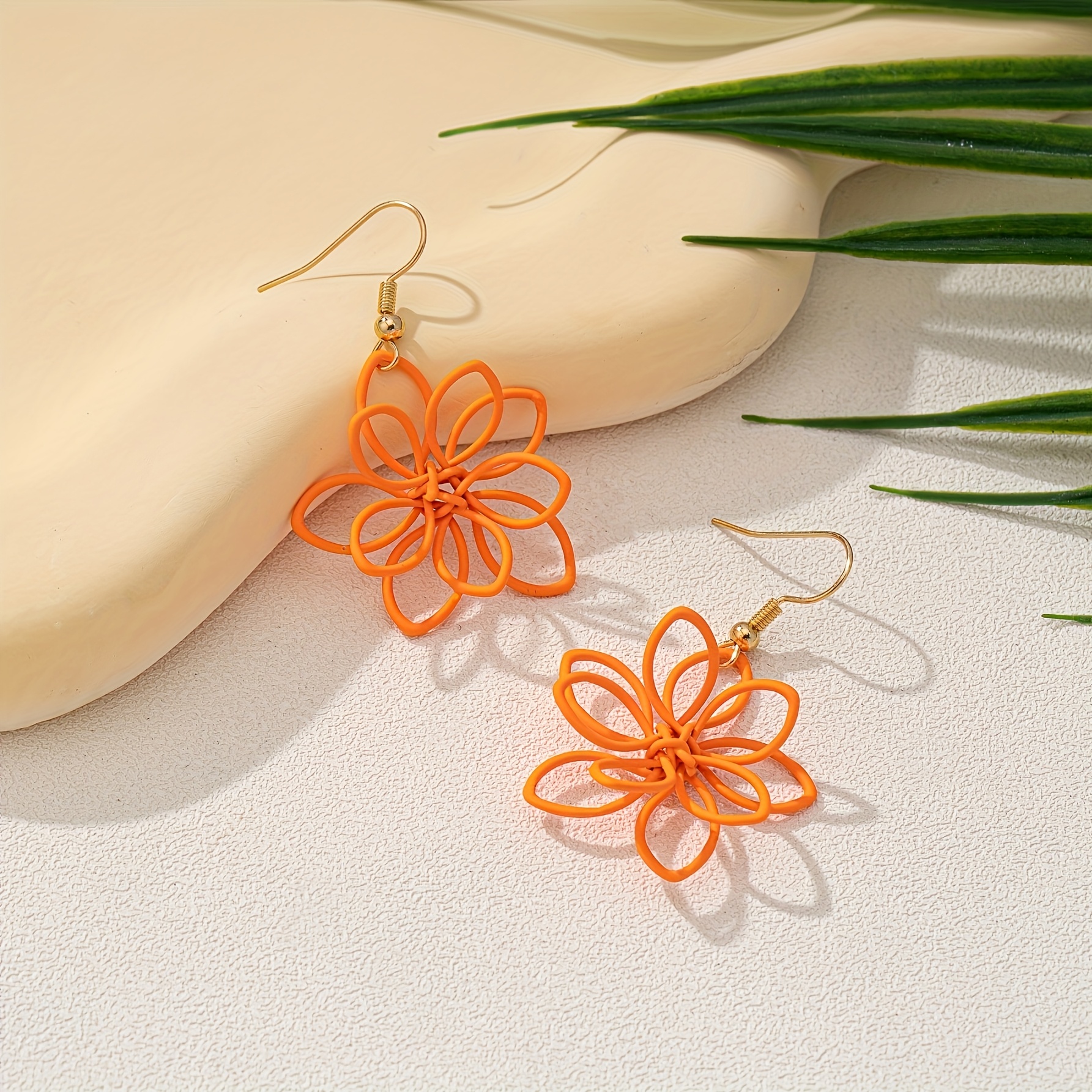 A Pair Of Casual Handmade Woven Iron Earrings In A Shape, Featuring A Warm Orange Color, Perfect For Holidays And Everyday Wear