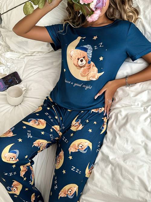 A Two-Piece Pajama Set for Women Featuring a Moon and Bear Print, Including a Comfortable Short-Sleeve Top and Matching Long Pants, Designed for Relaxed Wear at Home Throughout the Year