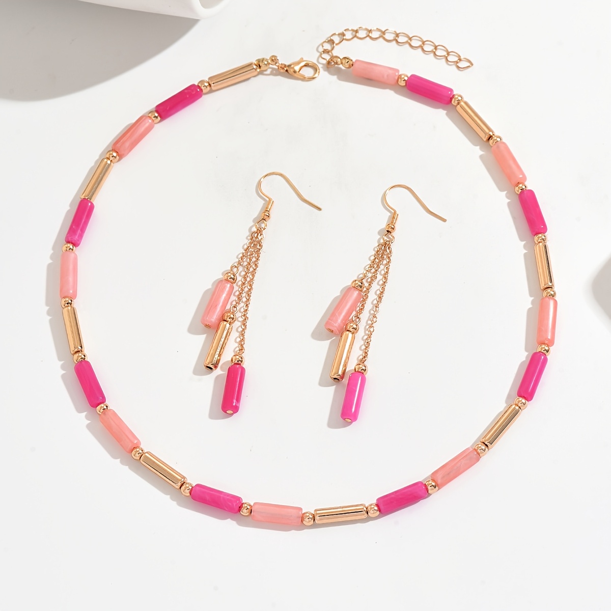 Image of A Two-piece Women's Jewelry Set Featuring A Stylish Necklace And Earrings For Autumn And Winter. It Includes Pink And Orange Long Cylindrical Beads Combined With Metal Tubes, A Tassel Chain