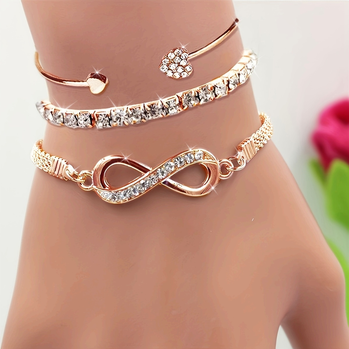 A Set of Three Women'S Bracelets And Bangles Featuring Wireless Symbols And Heart Designs Adorned with Rhinestones.
