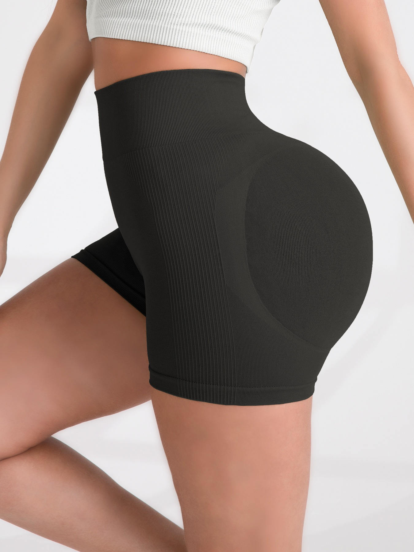 Person wearing black high-waisted shorts with a blurred background