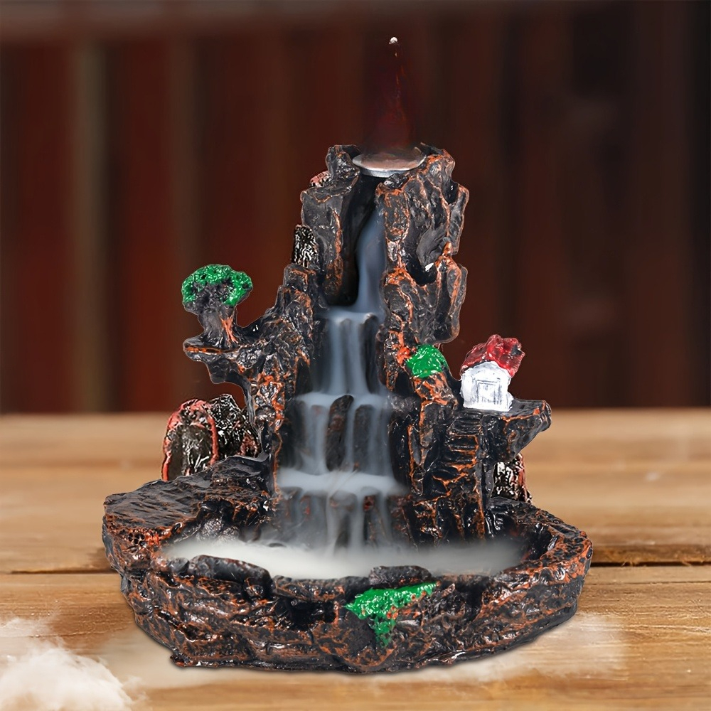 Mountain-shaped backflow incense holder with white incense smoke descending its ledges