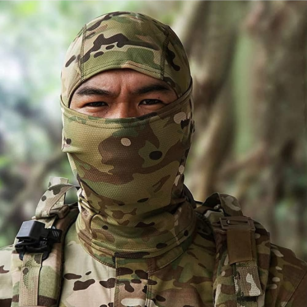 Hombre serio en una máscara de pasamontañas contra camuflaje militar