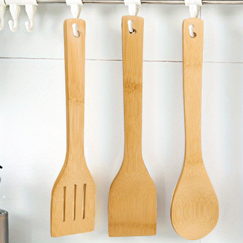 set of kitchen utensils including a bamboo spatula and a non stick frying pan spatula