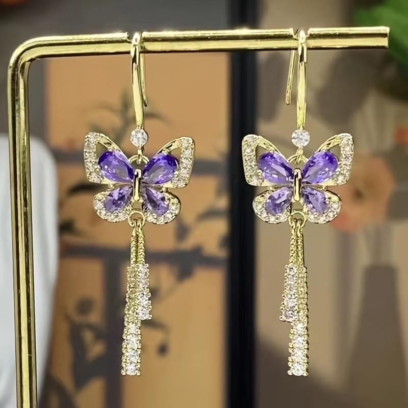 

A Women's Purple Butterfly Earring Inspired By The Exquisite Craftsmanship Of Rhinestones And Butterfly Tassels. Paired With Sparkling Crystals, Transform Into An With A Pink Gift Box