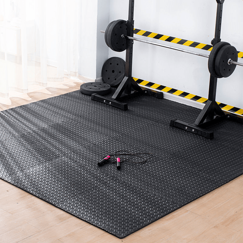A workout equipment standing on a black gym flooring mat