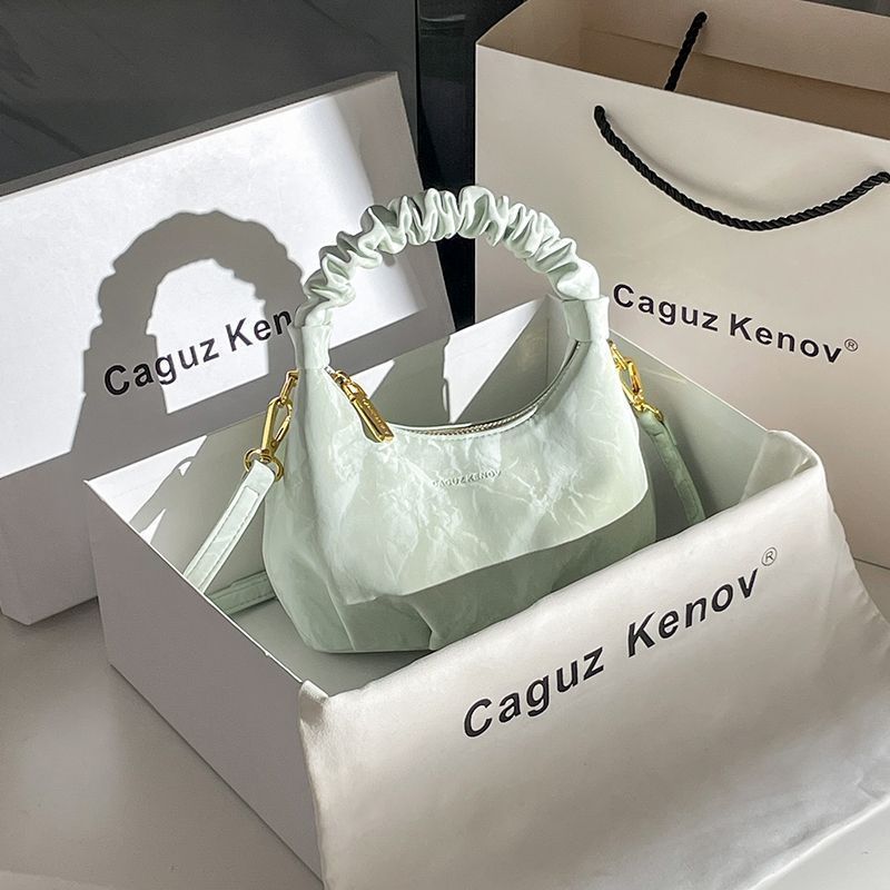 A Single Unit of The Latest Cloud Bag - a Small Pleated Clutch with an Adjustable Shoulder Strap, Featuring a Premium Matte End, Perfect for Everyday Use And Casual Events. This Compact Handbag Exudes Sophistication