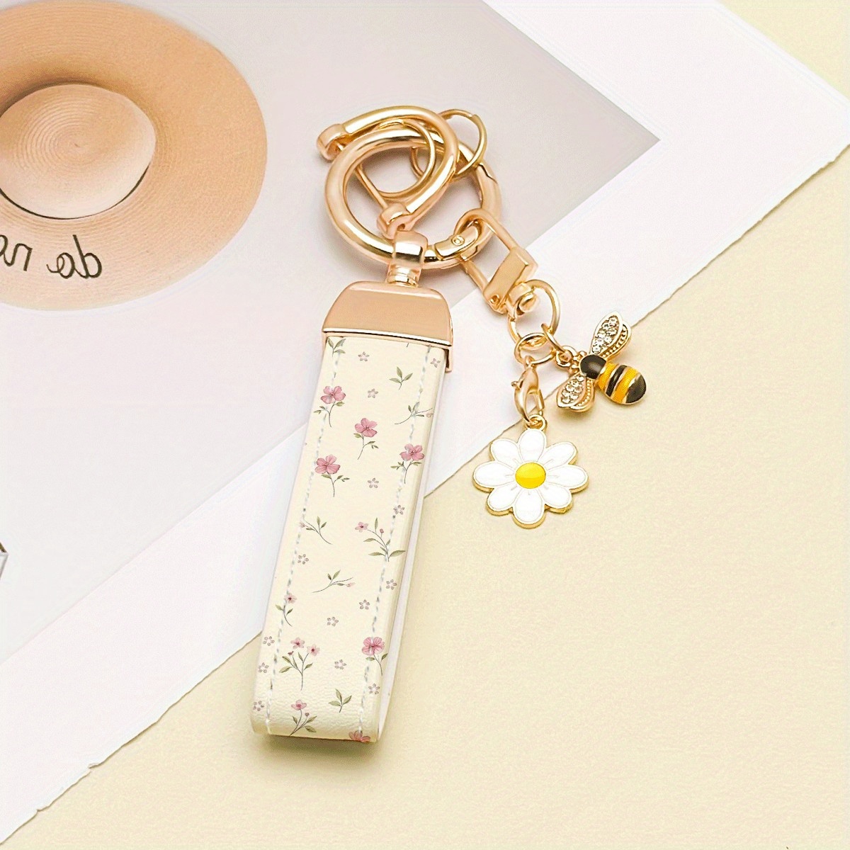 E-shop Ein einzelner Schlüsselanhänger aus Zinklegierung mit einem bedruckten Kunstleder-Design, ergänzt durch elegante Anhänger. Die rostfreie