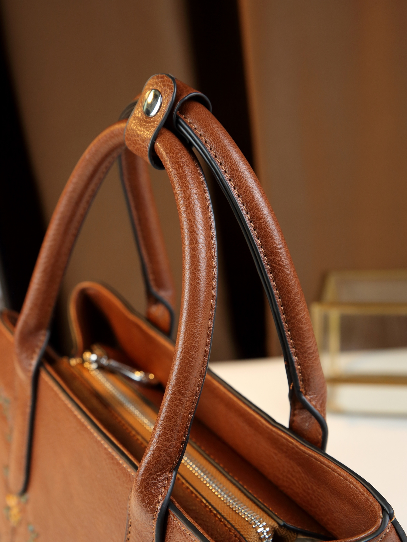 Light Brown Floral Print Handbag on table