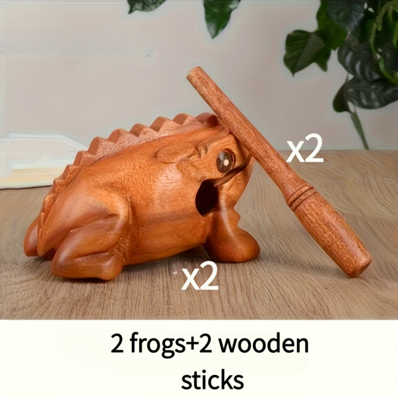 Two carved wooden frog percussion instruments with wooden sticks