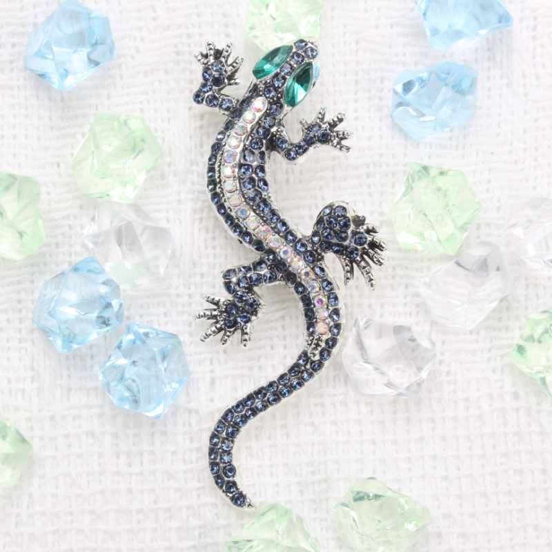 A Lizard-shaped Brooch With Blue And Green Rhinestones And Silvery Details, Perfect For Enhancing Clothing, Bags, Hats, And More. It Adds A Touch Of Edgy And Nature-inspired Charm To Outfits
