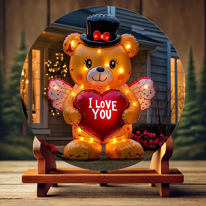 

An Inflatable Teddy Bear Wearing A Holds An Aluminum Poster With A Heart That Says "i Love You.