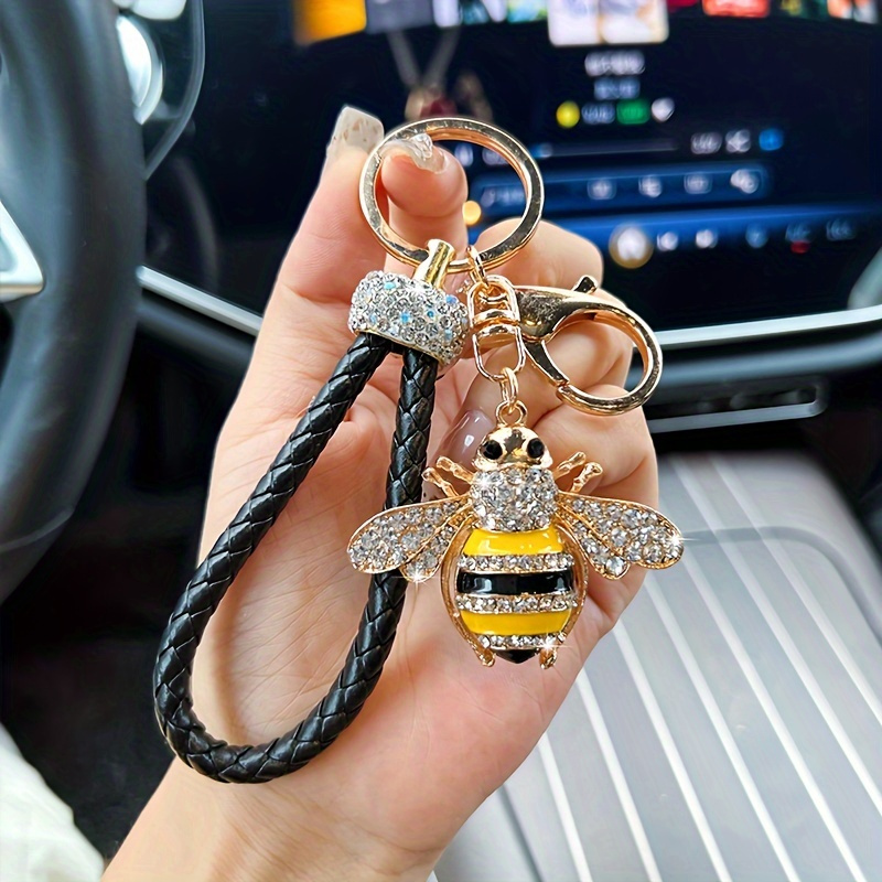 Image of A Stylish Bee Keychain With Sparkling Diamond Accents - Featuring A Black And Golden Woven Cord, Made Of Brass, It Makes A Suitable For Decorating Bags Or Cars, A Bee-themed Present