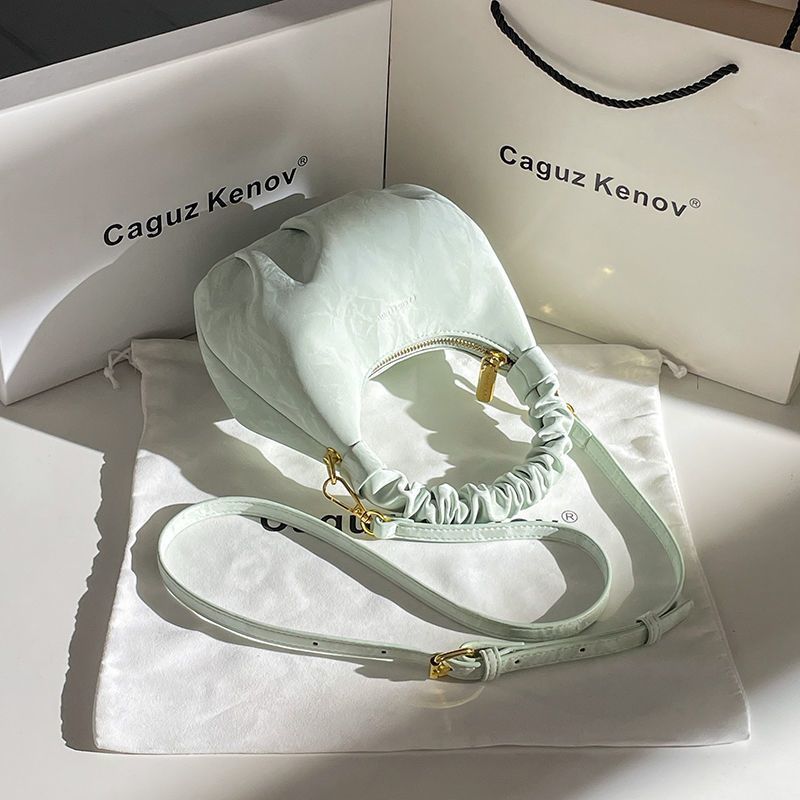 A Single Unit of The Latest Cloud Bag - a Small Pleated Clutch with an Adjustable Shoulder Strap, Featuring a Premium Matte End, Perfect for Everyday Use And Casual Events. This Compact Handbag Exudes Sophistication