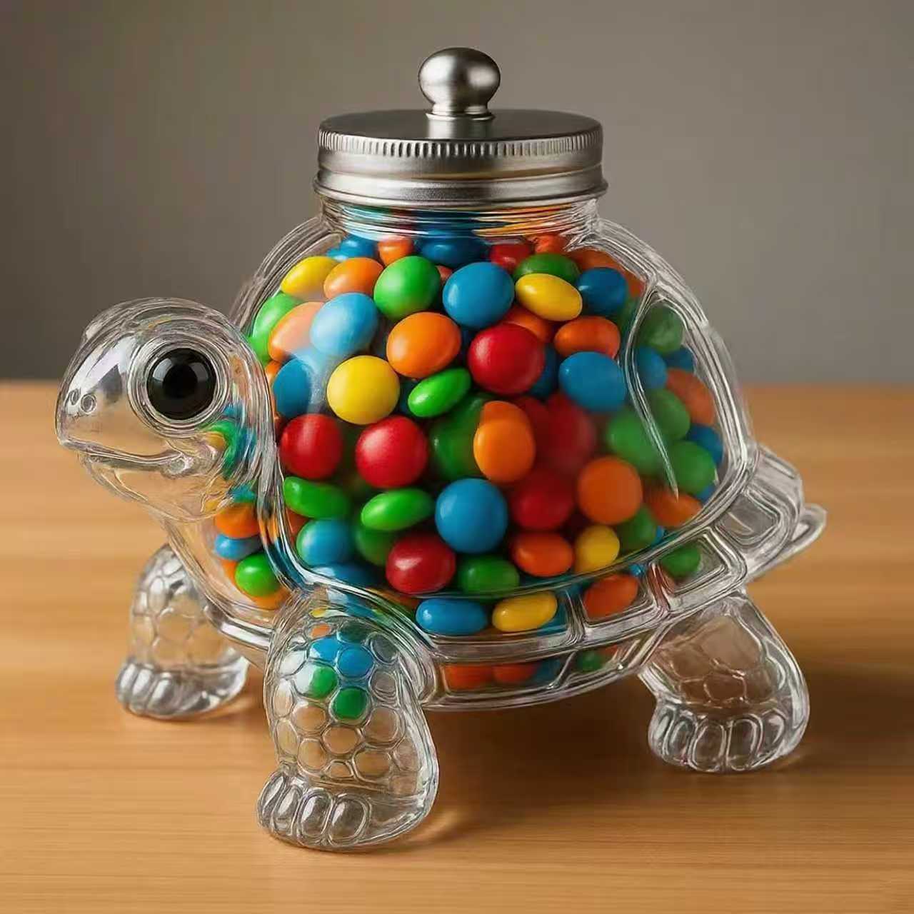 Clear turtle-shaped jar with a metal screw lid and colorful candy inside