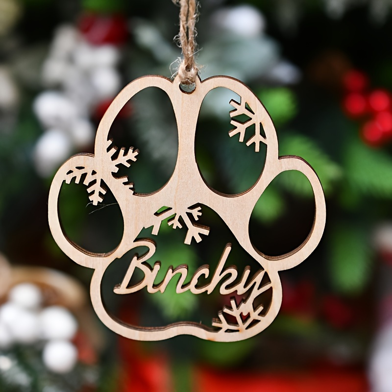 

A Personalized Wooden Dog Paw Ornament - A Modern Christmas Decoration For Pet Lovers, Featuring A Wooden Paw Design With Accents, Animal-themed, No Feathers, Hanging Decor.