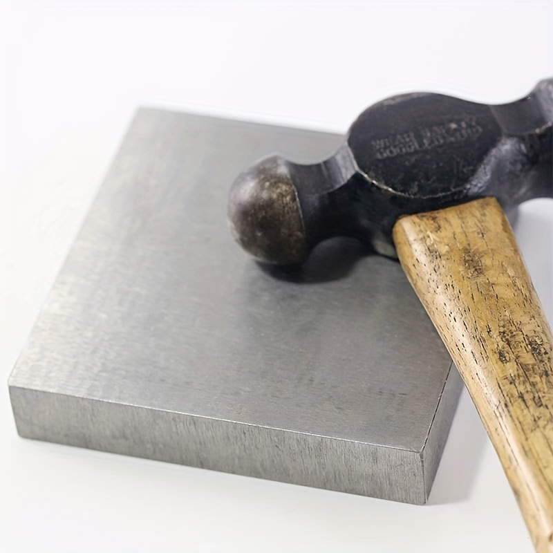 Herrero forja y hace detalles de metal con martillo y yunque en fragua
