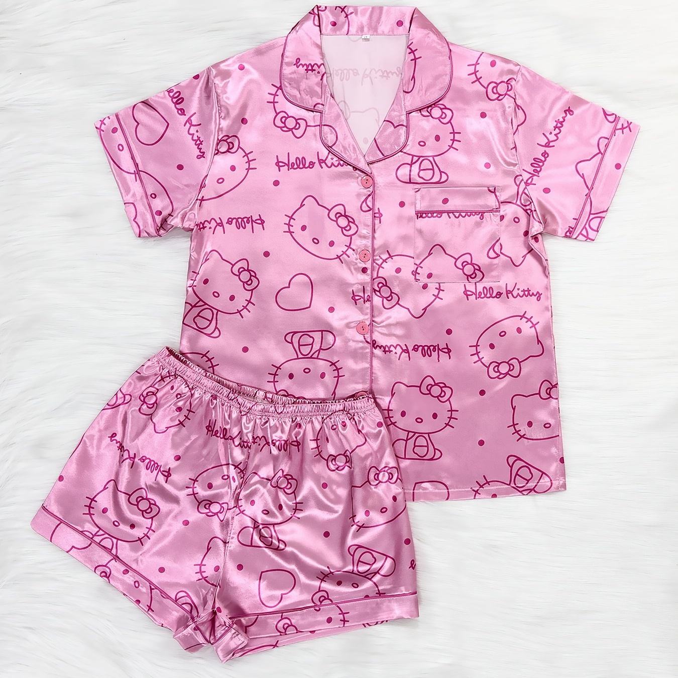 

Sanrio Hello Kitty Printed Satin Pajama Set, Featuring A Collared Button-up Short Sleeve Top And Waistband Shorts, A Cute And Casual Pink Loungewear Outfit.